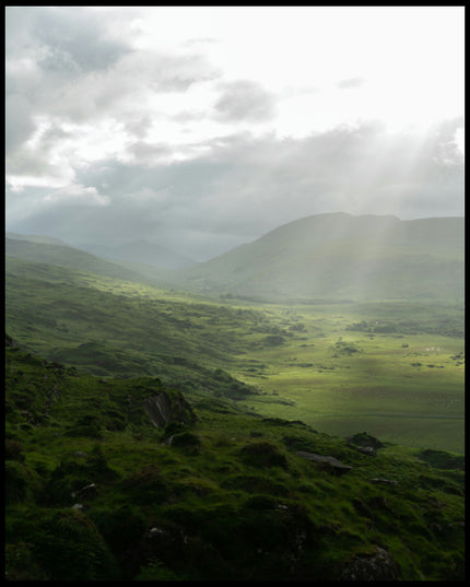 Ein Leinwandbild von einer grünen Landschaft in Irland mit Sonnenstrahlen.