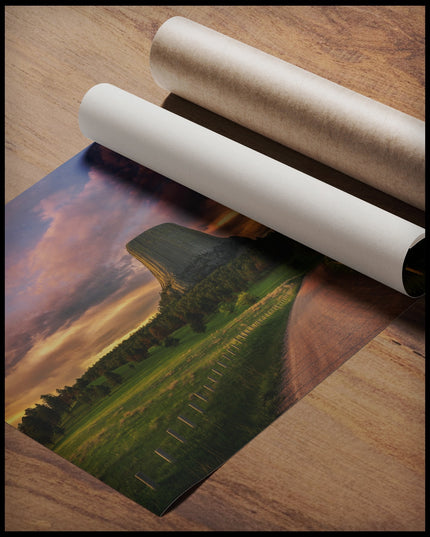 Ein Poster vom Devils Tower bei Sonnenuntergang, gerollt auf einer Holzoberfläche liegend