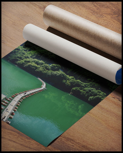 Ein Poster von einer schwimmenden Brücke auf einem grünlichen See, die in einen Wald hinein führt, gerollt auf einer Holzoberfläche liegend