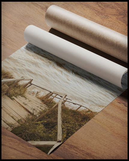 Ein Poster von einer Holztreppe die durch Dünen runter zum Strand führt, gerollt auf einer Holzoberfläche liegend