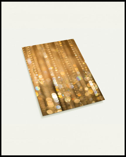 Eine Postkarte von goldenem Bokeh mit funkelnden Lichtreflexen.