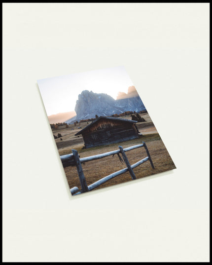 Eine Postkarte von einer rustikalen Hütte in einer herbstlichen Berglandschaft.