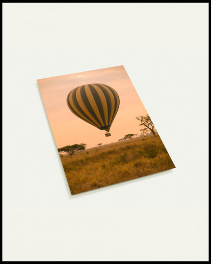 Eine Postkarte von einem Heißluftballon, der über der afrikanischen Savanne bei Sonnenaufgang schwebt.