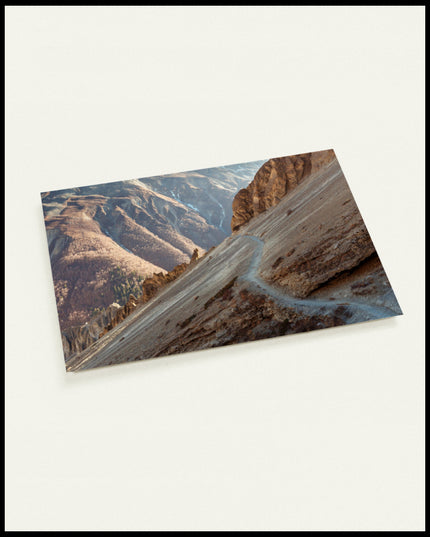 Eine Postkarte von einem Wanderweg in einer kargen, trockenen Berglandschaft ohne Vegetation.